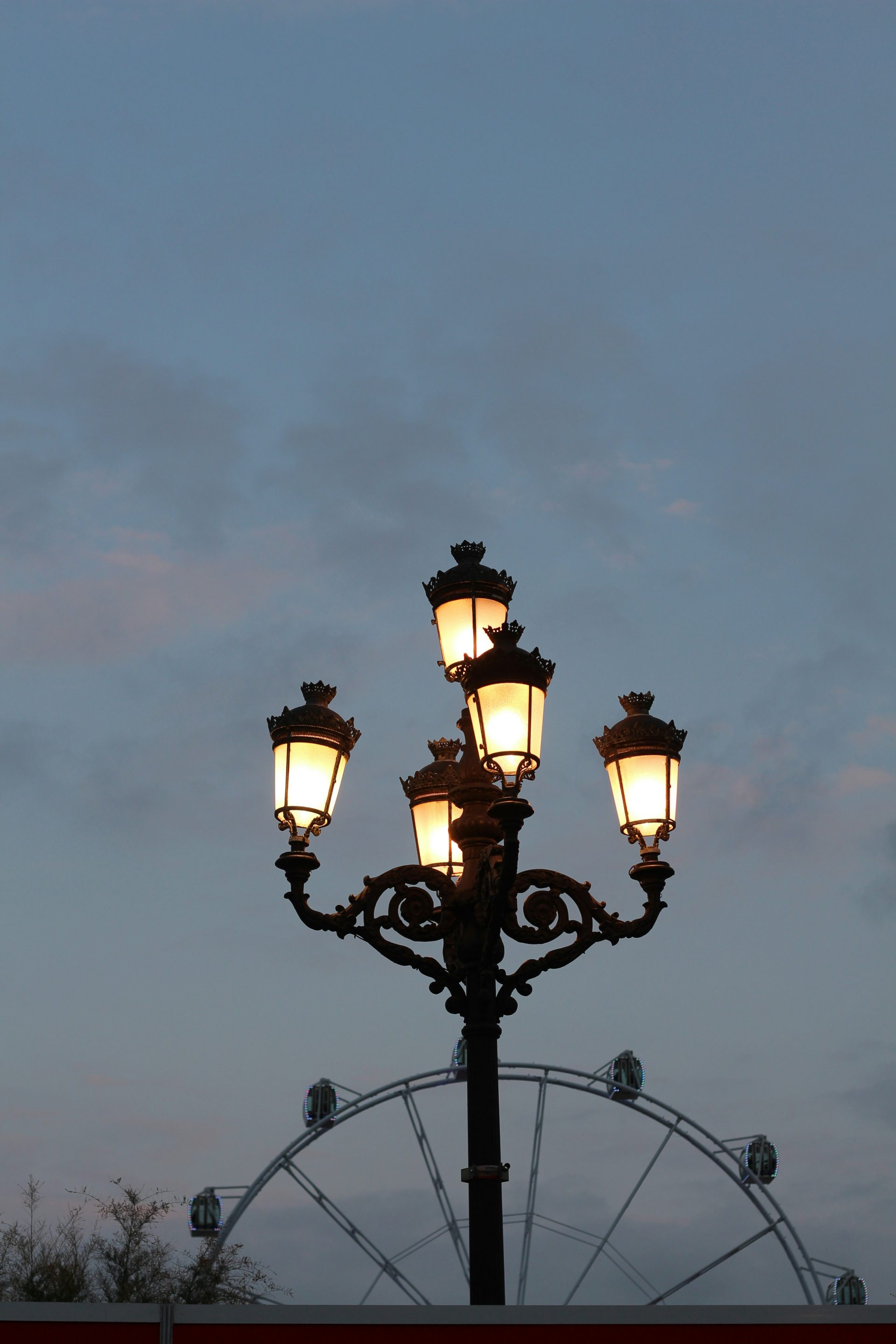 Una farola con una noria al fondo