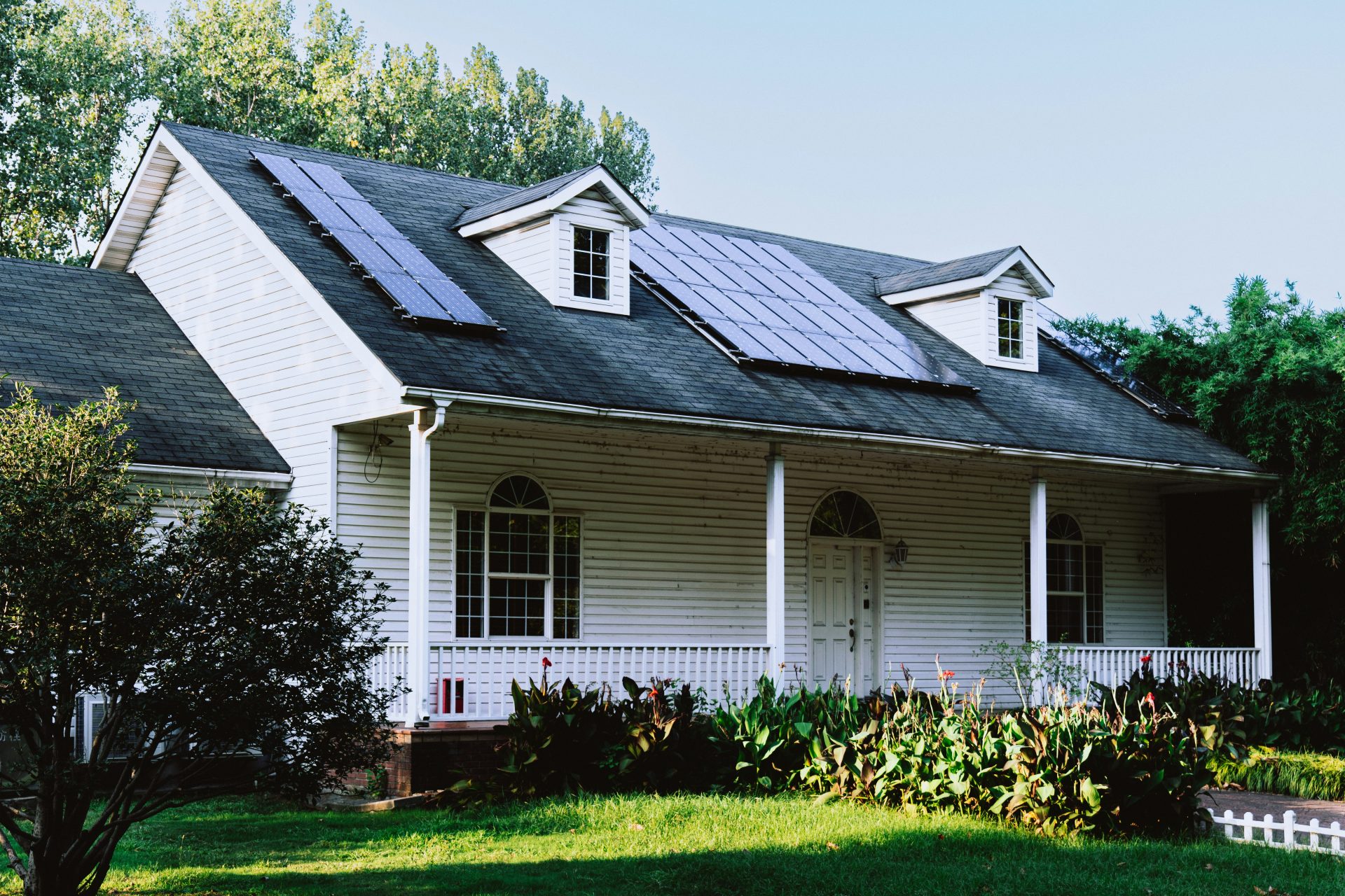 Una pequeña casa blanca con techo negro.